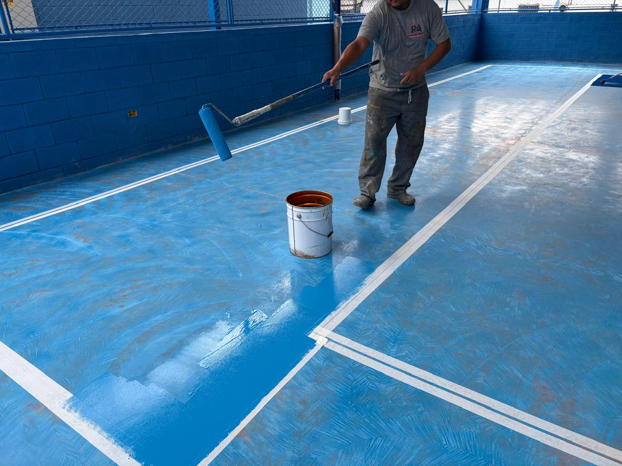 Execução de pintura epóxi em quadra esportiva do Atacadão em São Paulo
